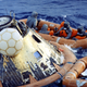 The Apollo 11 astronauts, in orange, being disinfected upon successfully returning back to Earth and landing in the Pacific ocean.